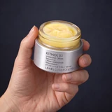 El tarro abierto de Retinol 03 en la mano