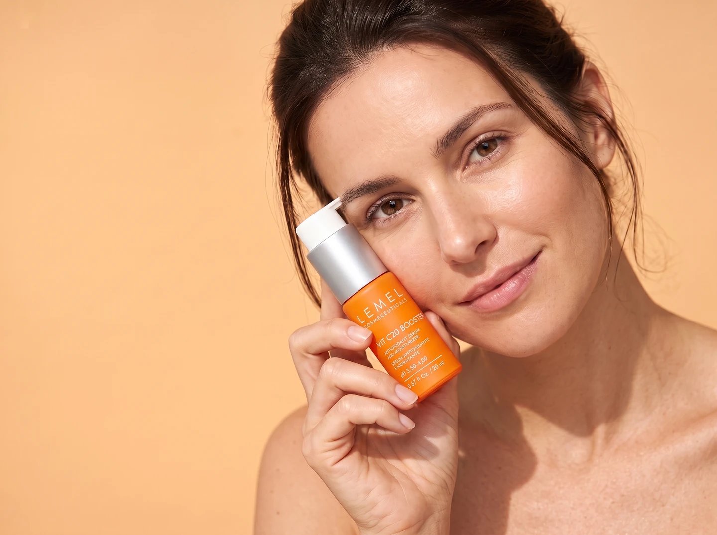 Aplicación con toques suaves en la mejilla, con Vit C20 Booster en la otra mano