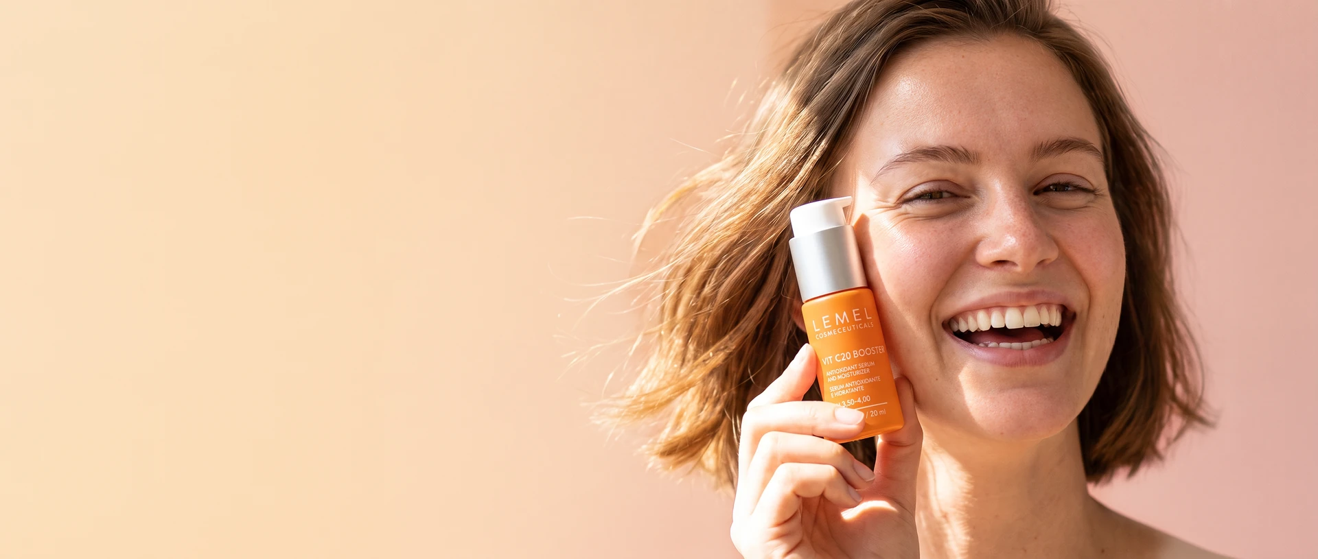 Mujer sonriendo con Vit C20 Booster de Lemel, con luz cálida