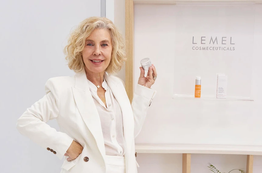 Dra. Velia Lemel en su clínica, vestida de blanco y sosteniendo un producto Lemel